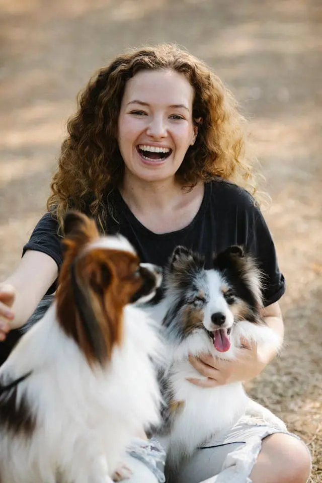 Happy woman with two dogs on her lap